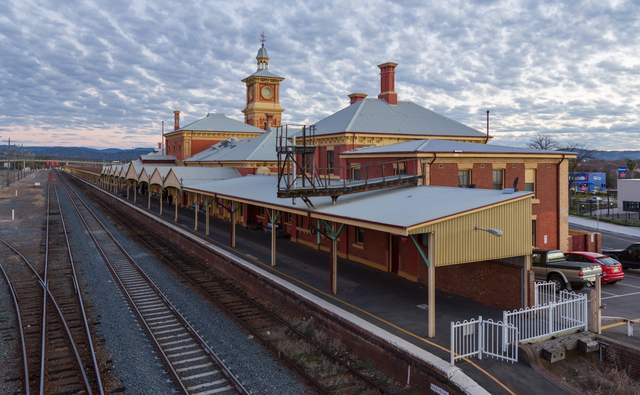 Elevated view of Albury’s clock-tower station building, long canopy and several parallel railway tracks.