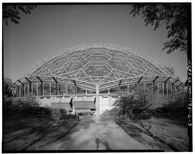 An archival black-and-white exterior of the geodesic greenhouse, with its complete scan border and photographer’s shadow.