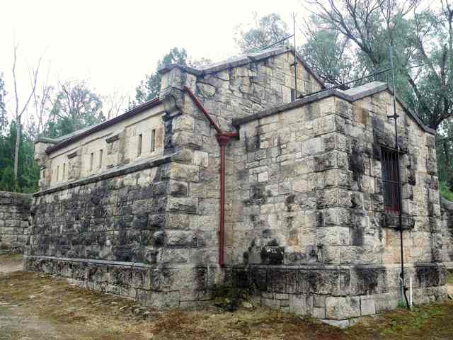 The magazine’s granite walls, projecting buttresses, barred entrance and metal rods are visible in a close exterior view.