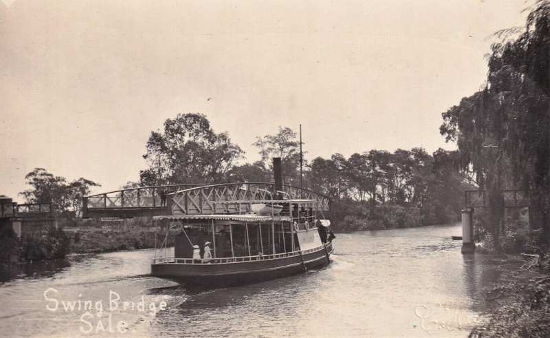 Historical postcard of a small steamer beside the swung bridge, with a clear gap across part of the river and original postcard lettering visible.