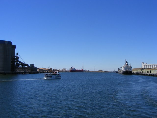 Ships, silos and waterfront buildings line a broad reach of the Port River.