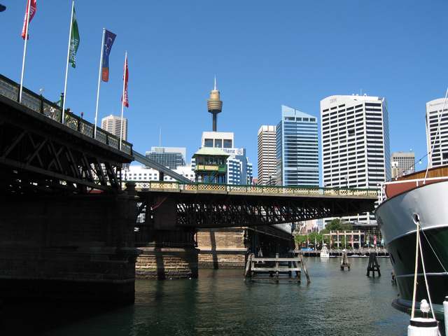 The swing span is turned across the harbour beside timber approach trusses and a small operator cabin.