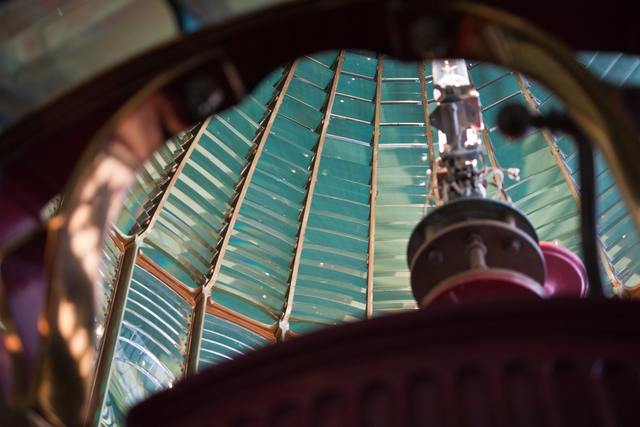 Stepped glass prisms and metal framework seen from inside the lighthouse lens.