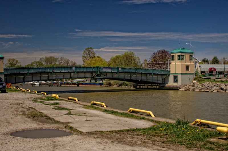 Closed lift bridge spanning Kettle Creek, with its control building at the right and a quay in the foreground.